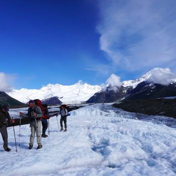 Backpackers hiking on Kennicott glacier in Wrangell St. Elias National Park