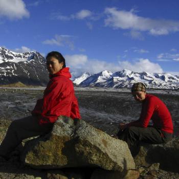 Backpackers rest at Bremner Glacier on Seven Pass route in Wrangell St. Elias National Park, Alaska